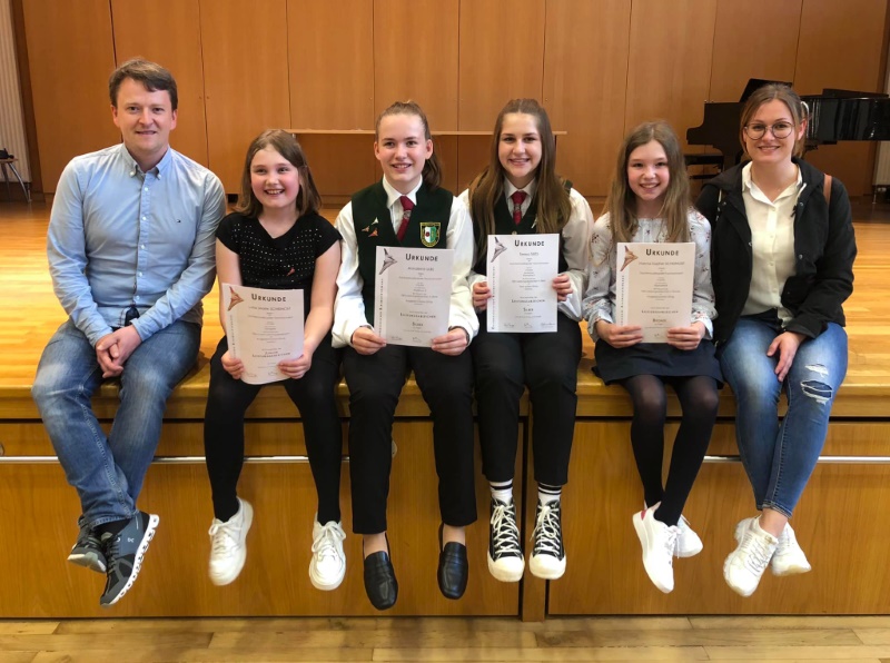 Kapellmeister Stephan Kaufmann zusammen mit erfolgreichen Jungmusikerinnen und Jugendreferentin Christina Hirschmugl